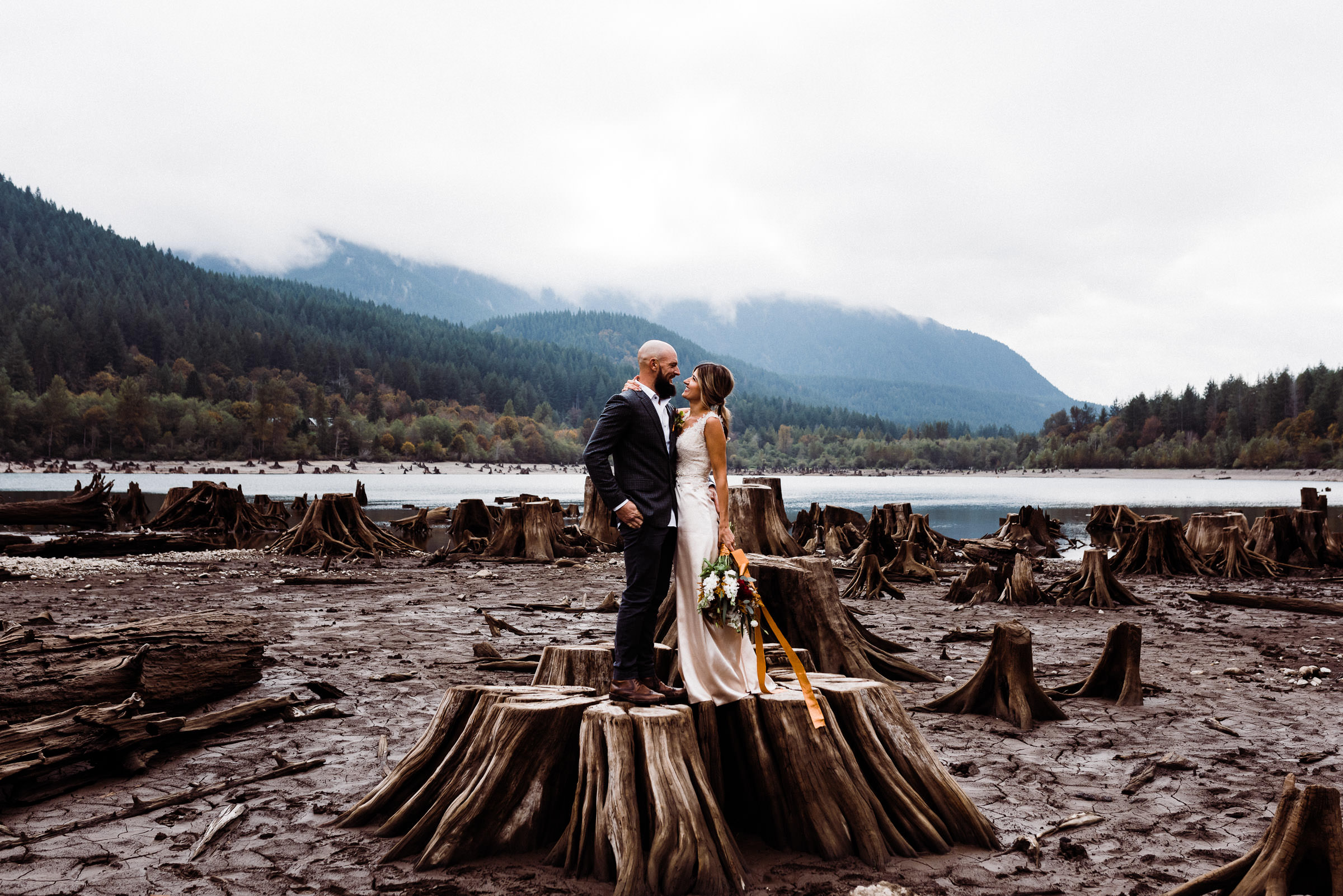 A bride and groom standing on a tree stump during their Seattle elopement.