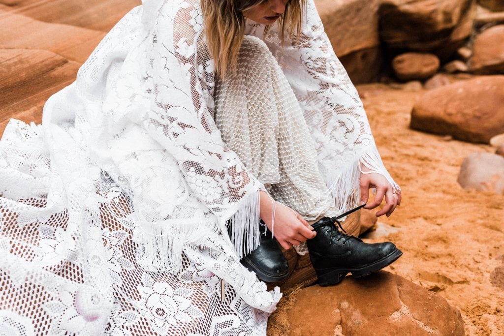 Bride tying her hiking boots during her hiking elopement.