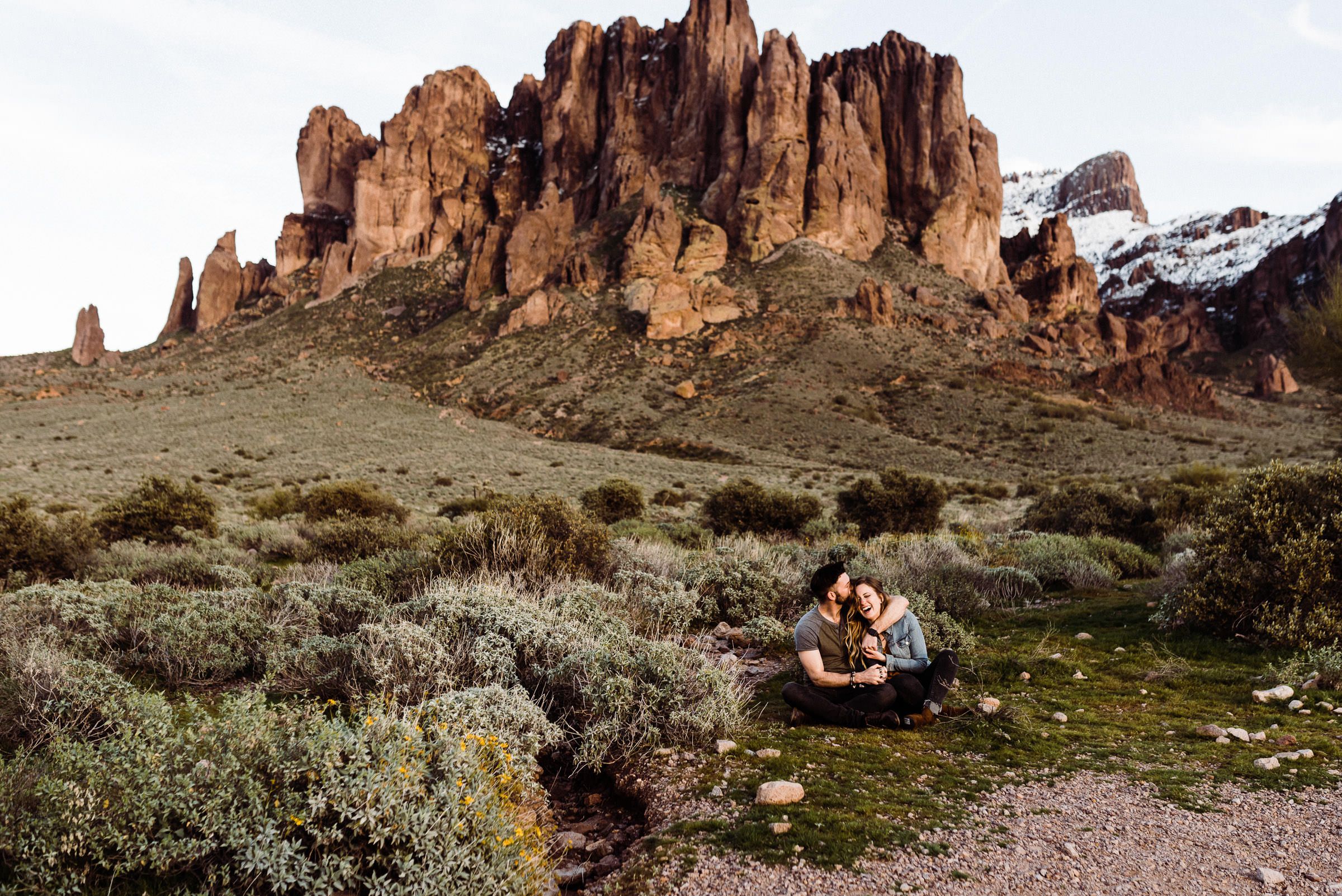A couple laughing in the Superstition Mountains photographed by an Arizona wedding photographer