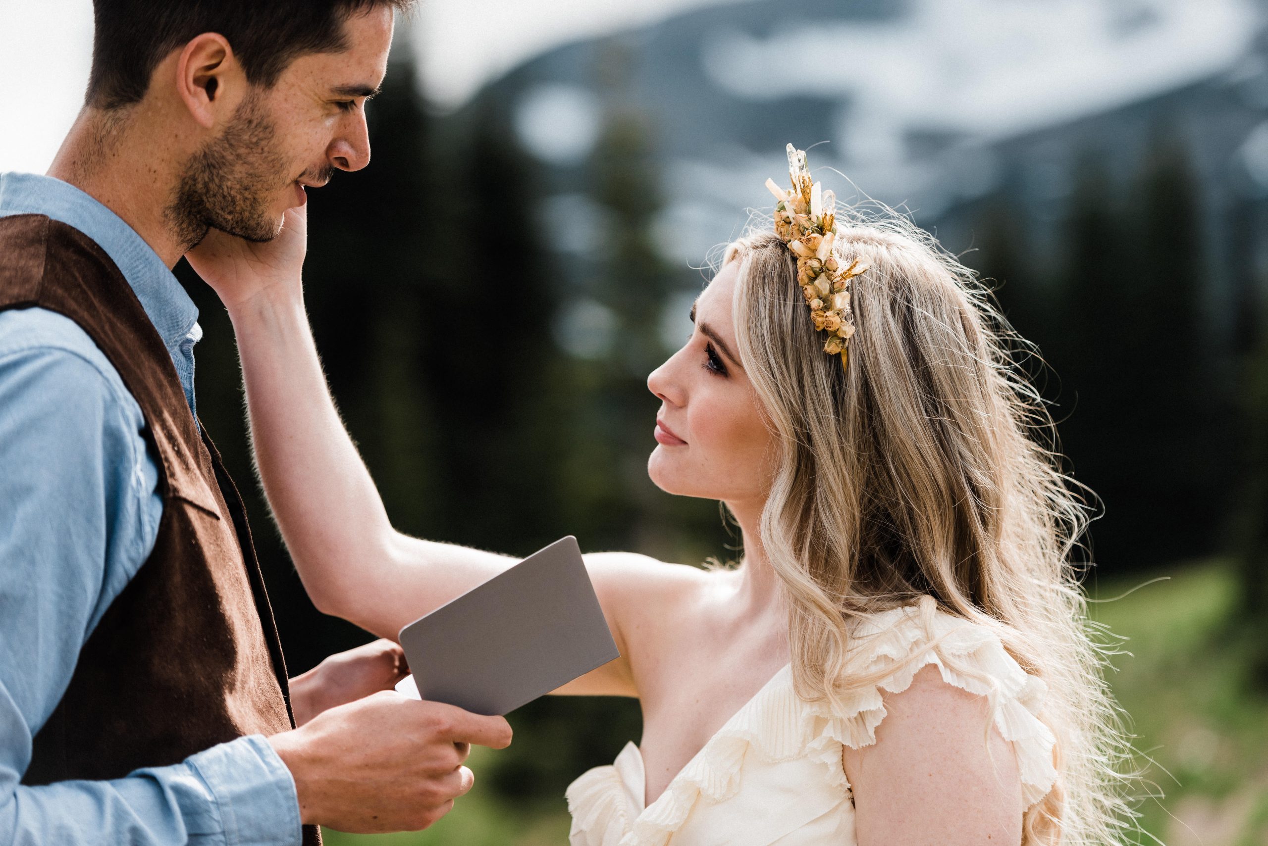 Groom reading personal wedding vows to bride during an adventurous mountain elopement.