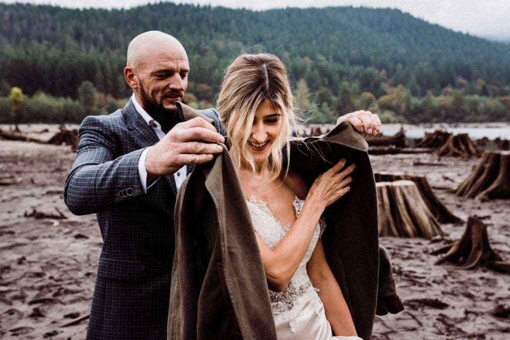 Groom putting a jacket around a bride at their adventure hiking elopement.
